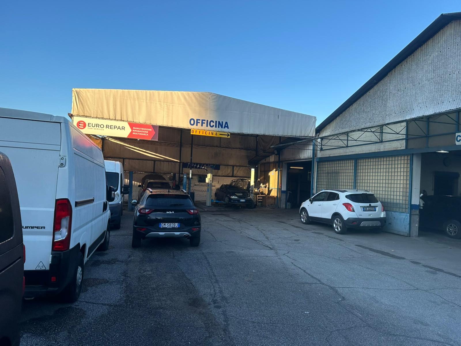 Piazzale e ingresso dell'officina di carrozzeria con i veicoli in attesa di lavorazione